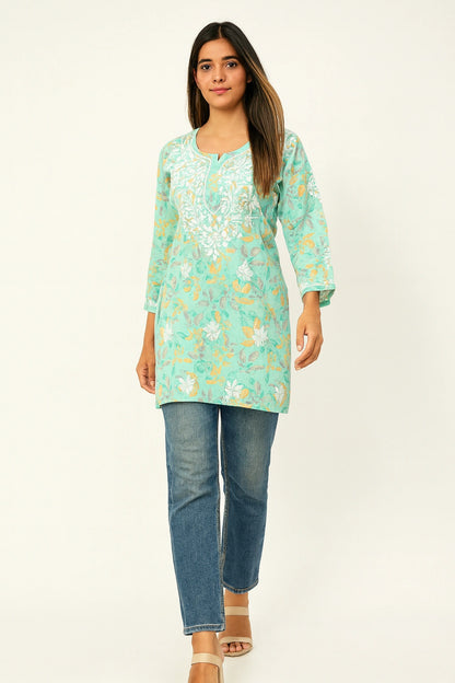 lucknowi chikankari Woman wearing a light blue floral tunic and jeans on a white background