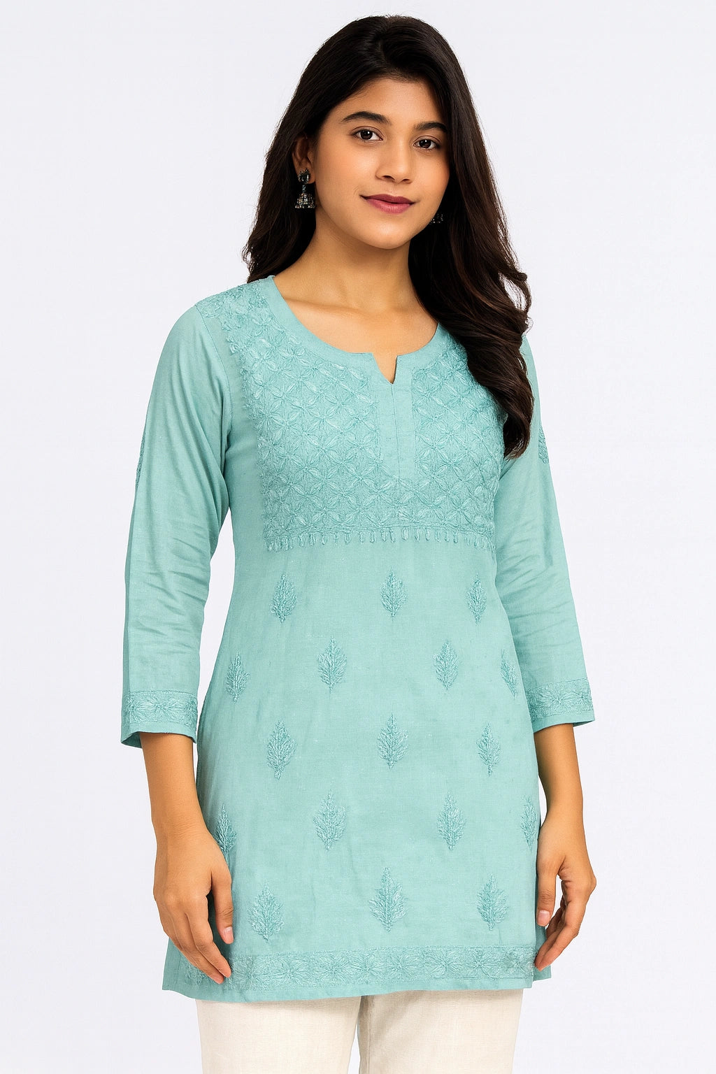 Woman wearing a light blue embroidered kurta against a white background