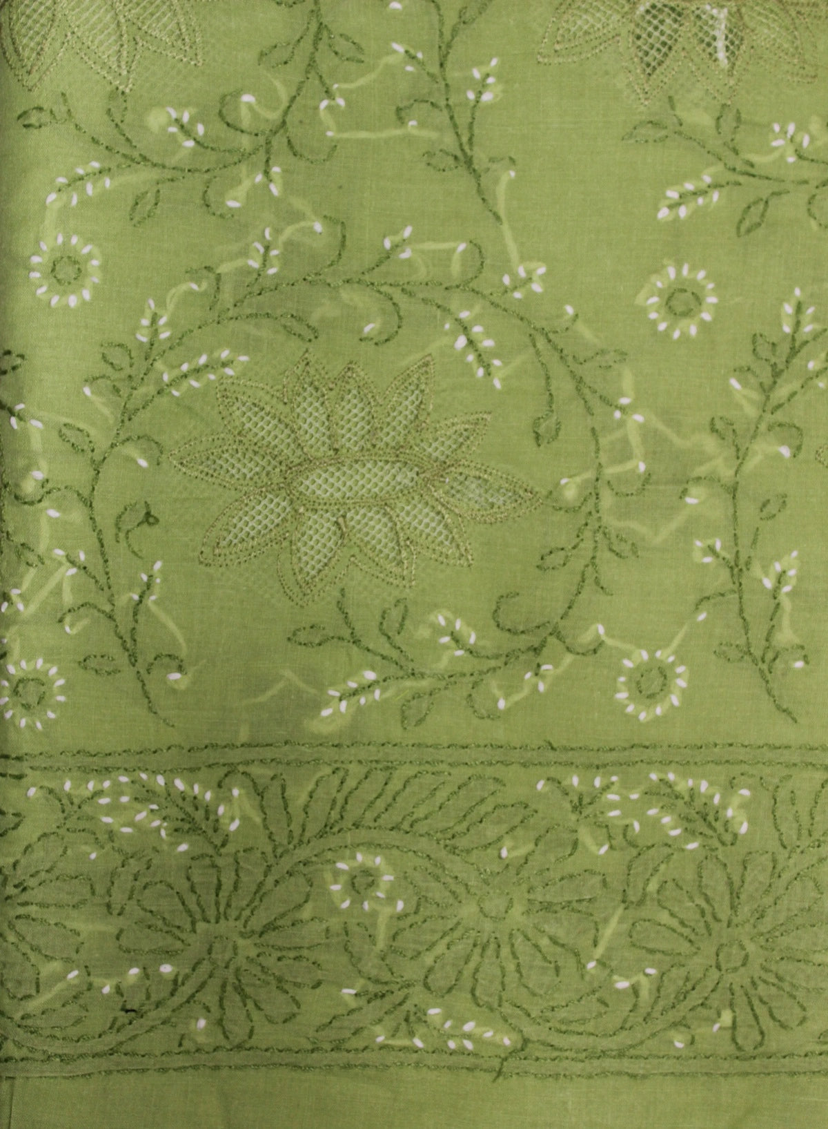 Close-up of green fabric with intricate floral embroidery