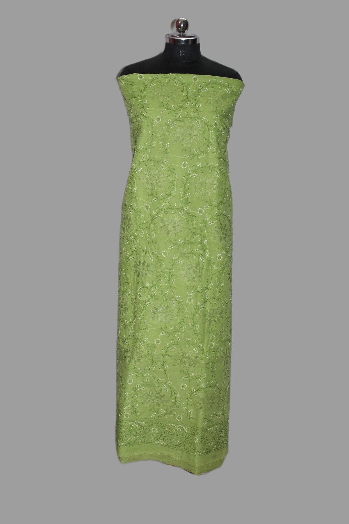 Green strapless dress on a mannequin against a gray background