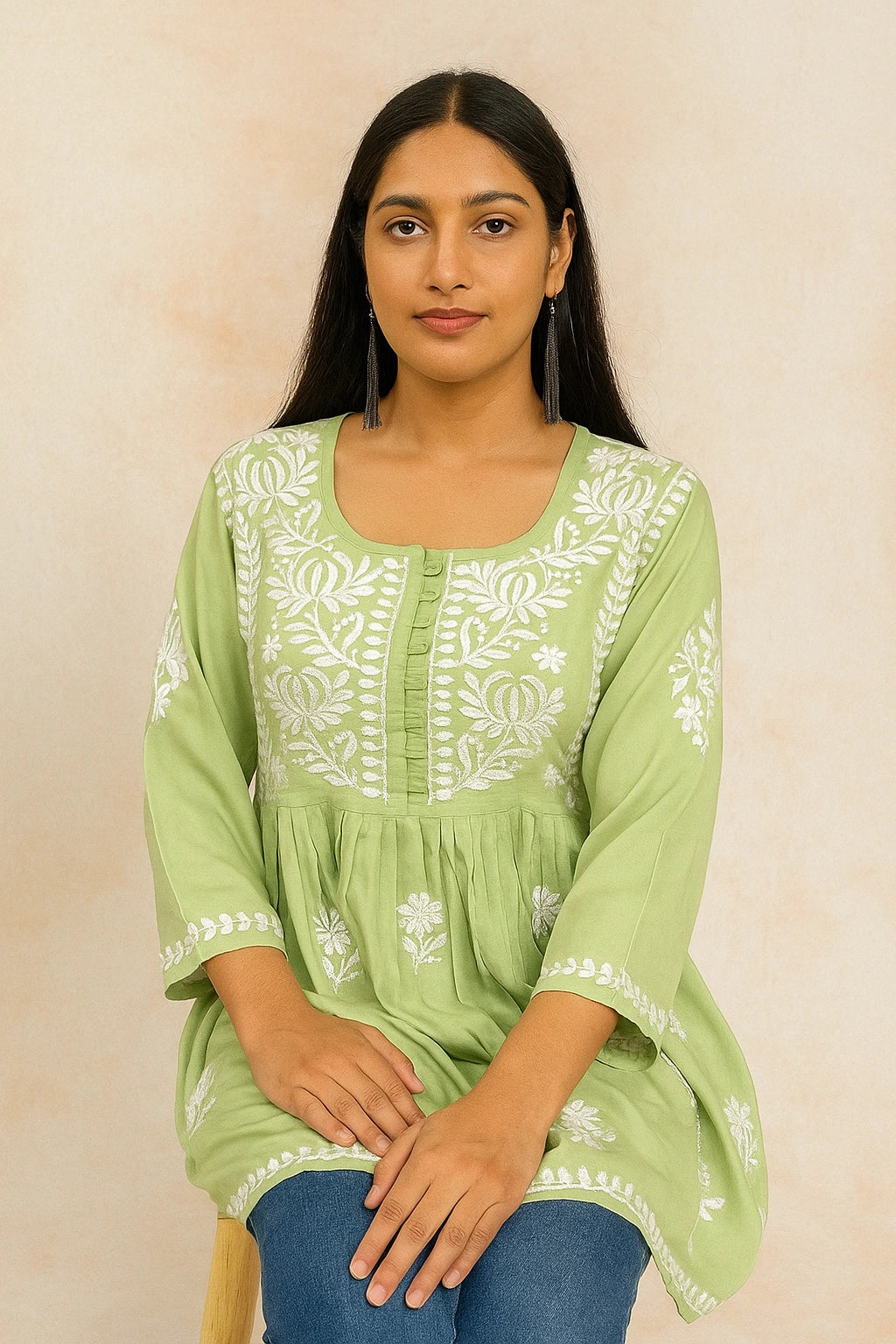 Woman wearing a green embroidered kurta on a beige background