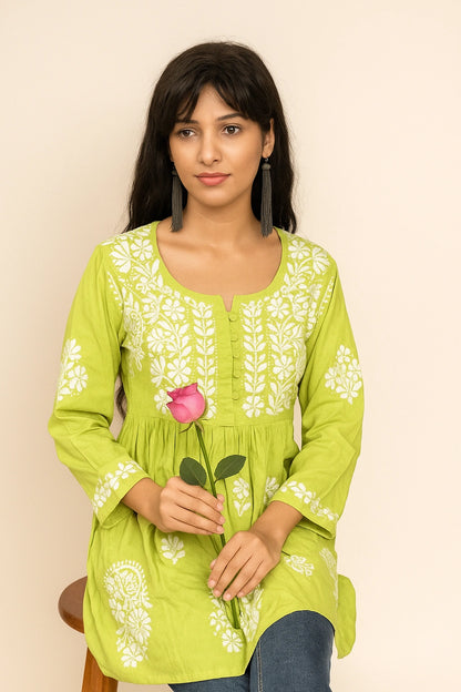 Woman wearing a green embroidered kurta on a beige background