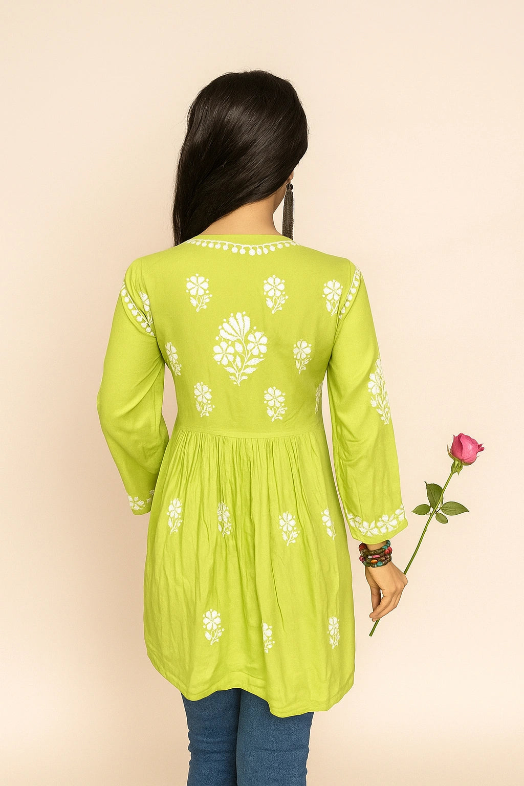 Person wearing a lucknowi chikankari light green top with a subtle pattern on a beige background