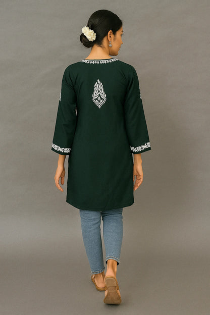 Person wearing a lucknowi chikankari light green top with a subtle pattern on a beige background