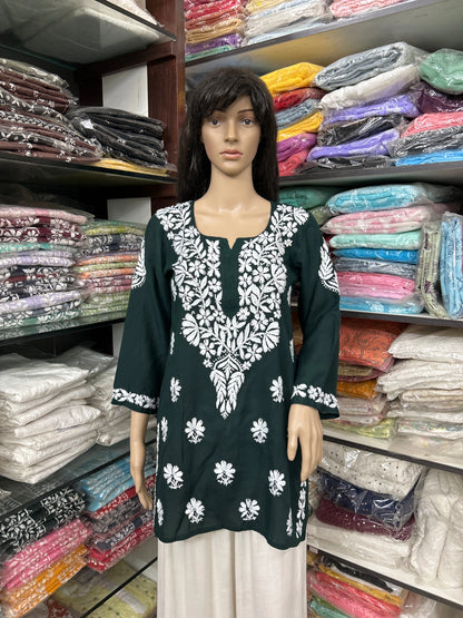 Mannequin wearing a lucknowi chikankari green dress in a fabric store.