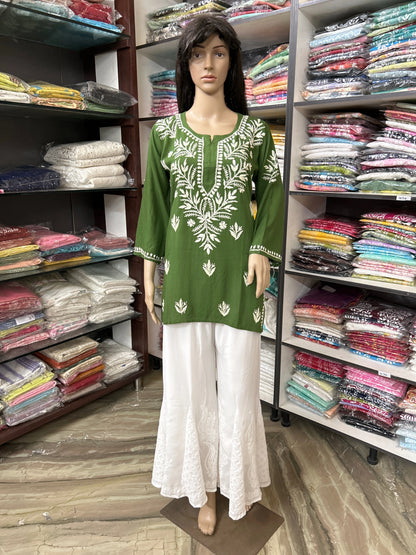 Mannequin wearing a lucknowi chikankari green and white outfit in a fabric store