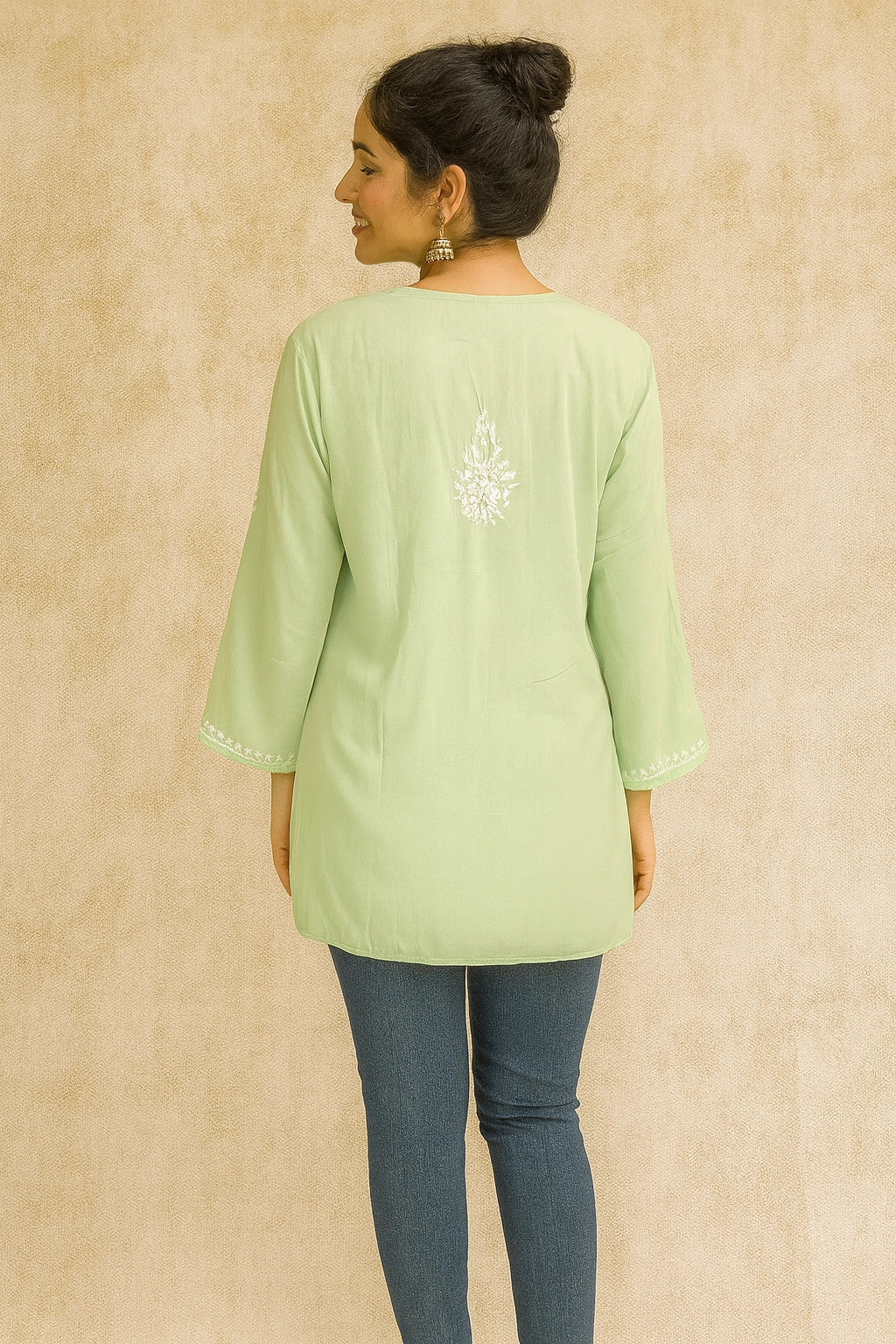 Woman wearing a lucknowi chikankari light green kurta with a subtle design on a beige background
