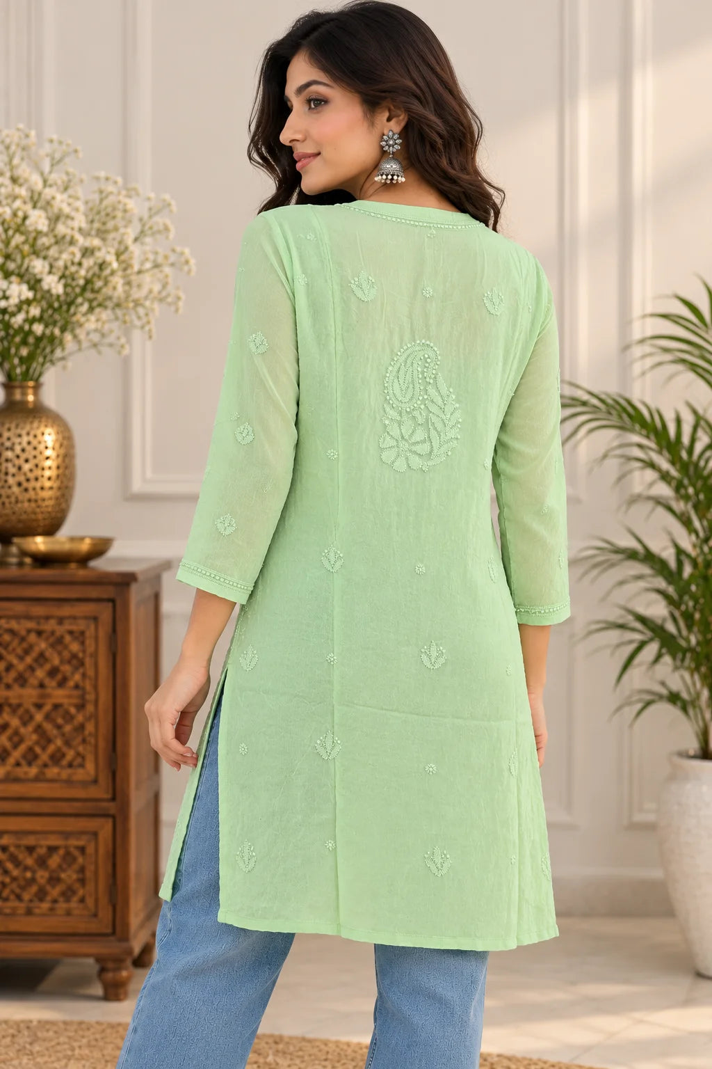 Woman wearing a lucknowi chikankari green-colored kurta with white floral patterns