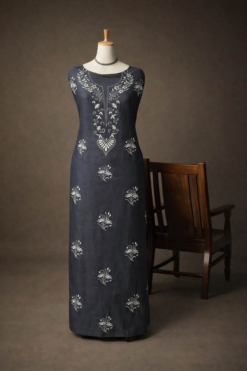 Navy blue dress with silver embroidery on a mannequin against a brown background