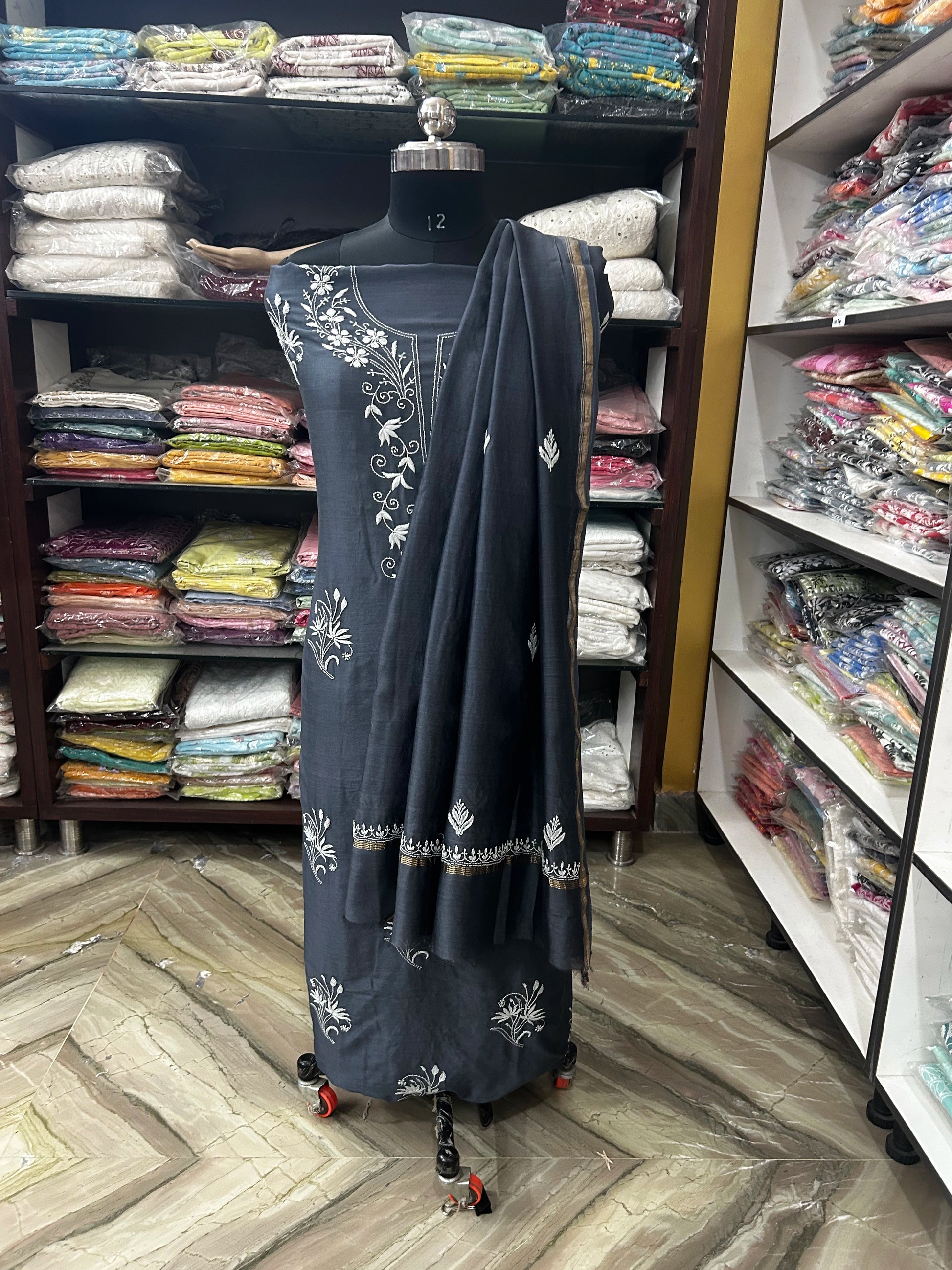 Black embroidered dress on a mannequin in a fabric store