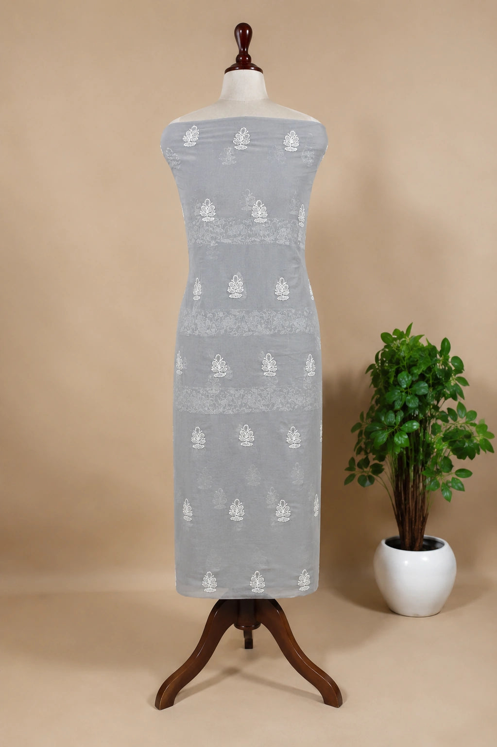 Lucknowi Chikankari Gray dress with white patterns on a mannequin against a beige background