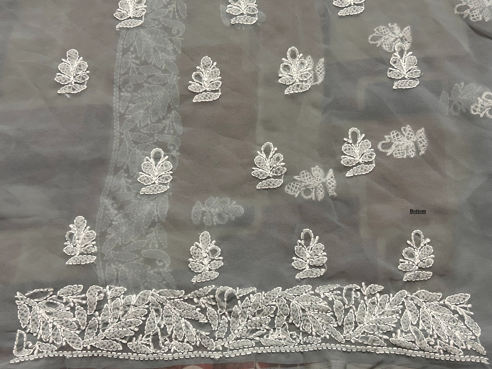 Dark fabric with intricate white floral embroidery