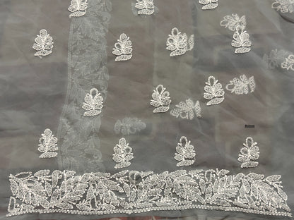 Dark fabric with intricate white floral embroidery