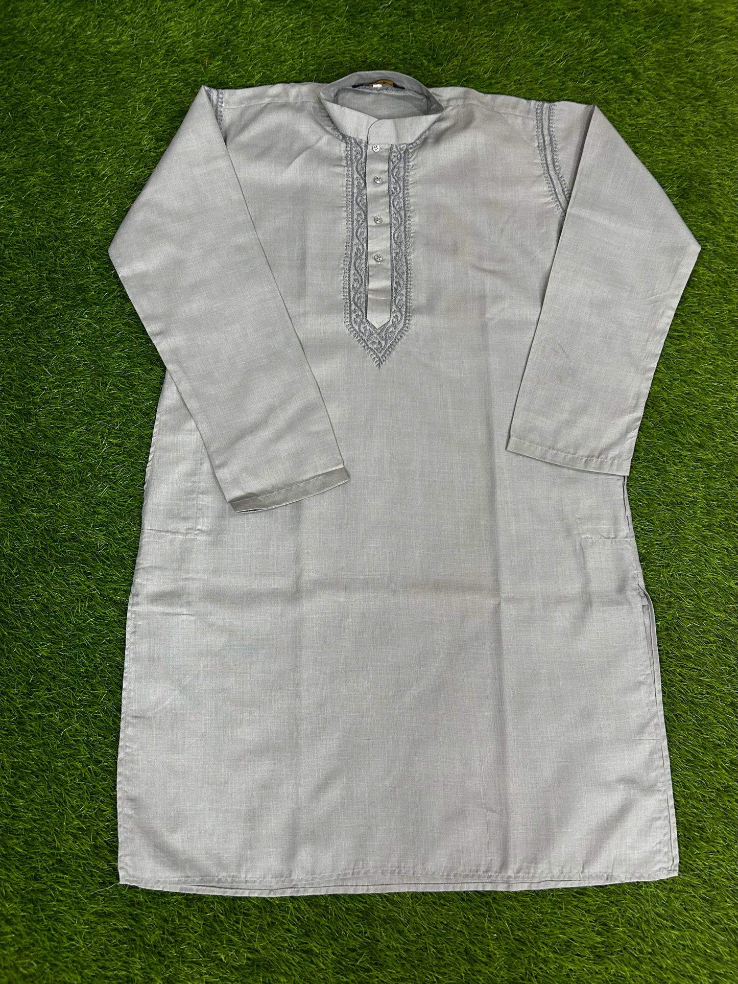 Light gray kurta with embroidery on a green background