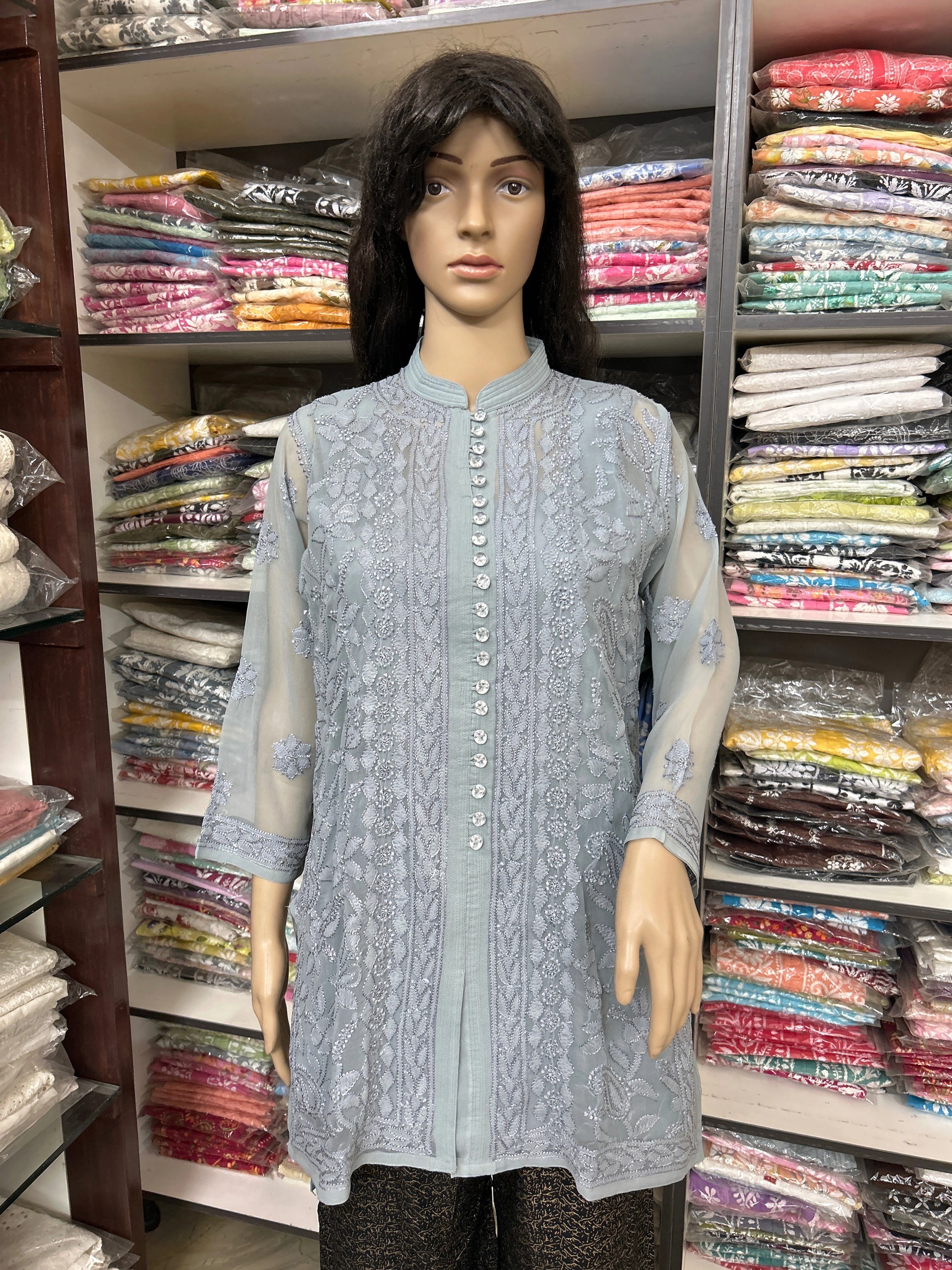 lucknowi chikankari Mannequin wearing a light blue embroidered kurta in a fabric store.