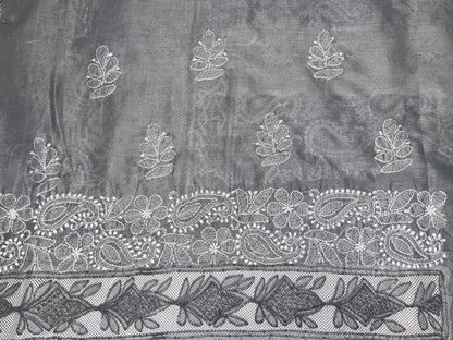 Decorative fabric with intricate white embroidery on a dark background