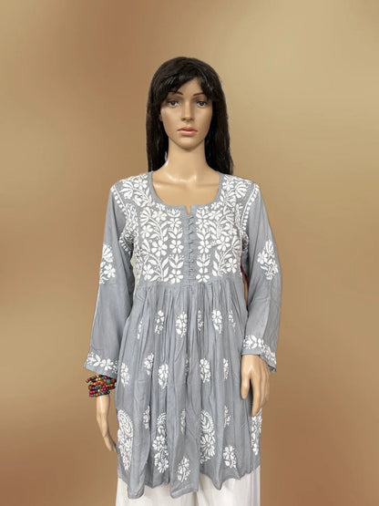 Mannequin wearing a lucknowi chikankari grey top in a fabric store.