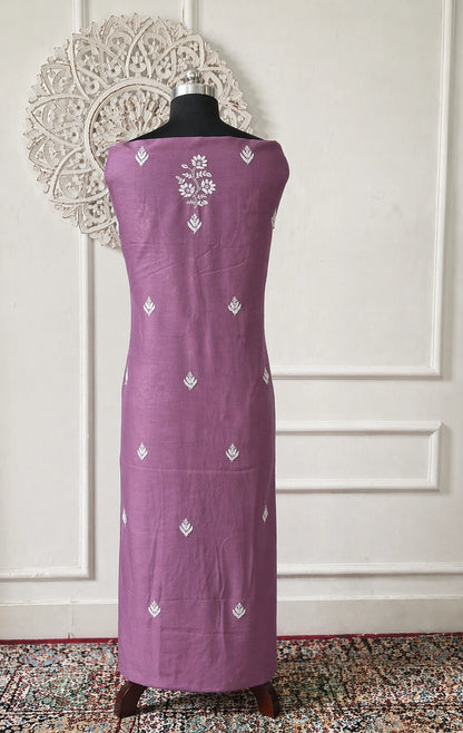 Lucknowi Chikankari Purple dress with white patterns on a mannequin against a decorative wall.