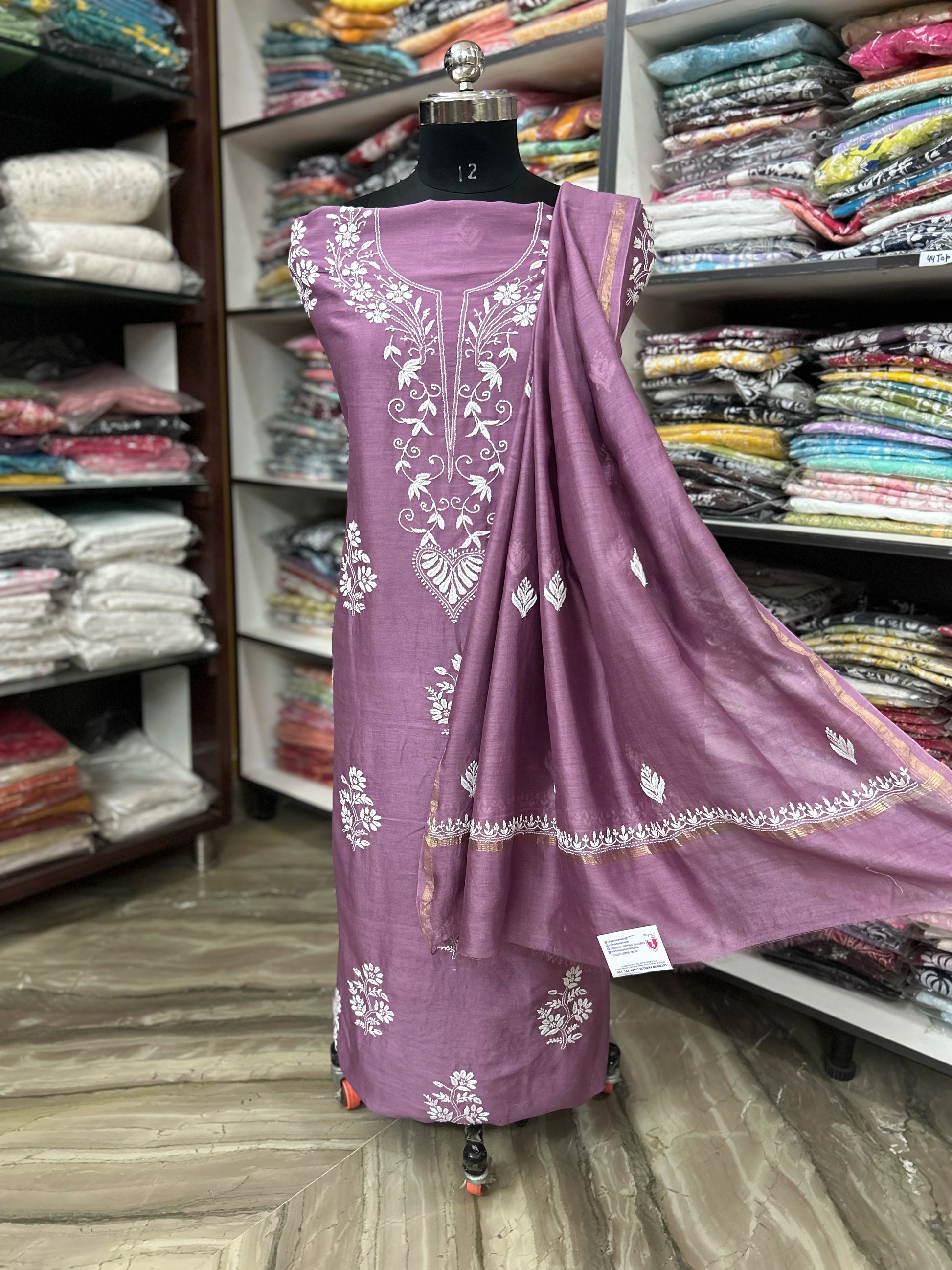 Purple embroidered outfit on a mannequin in a fabric store.