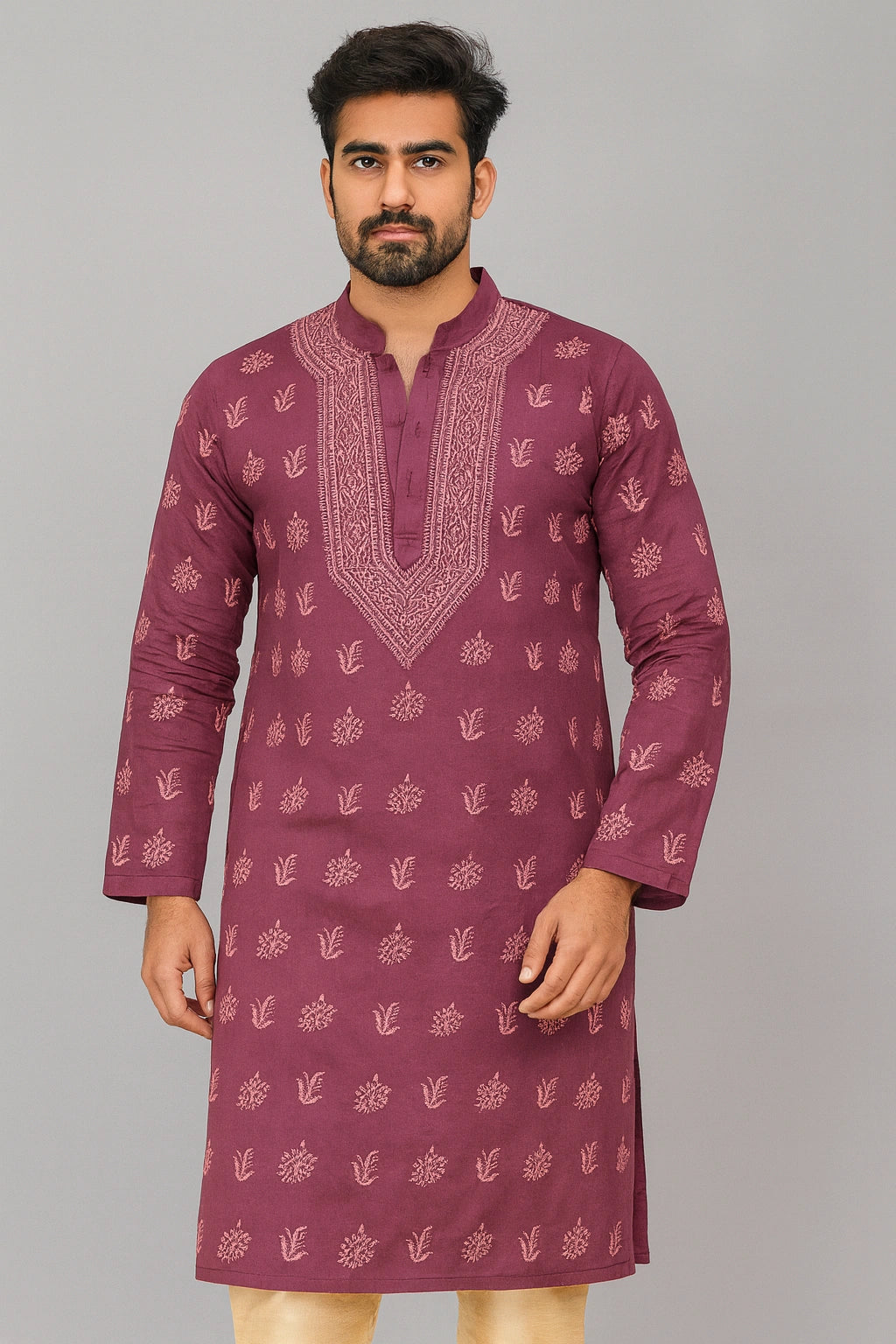 A man wearing a maroon long-sleeve kurta with light pink floral prints and a matching embroidered V-neckline, standing against a solid gray background.