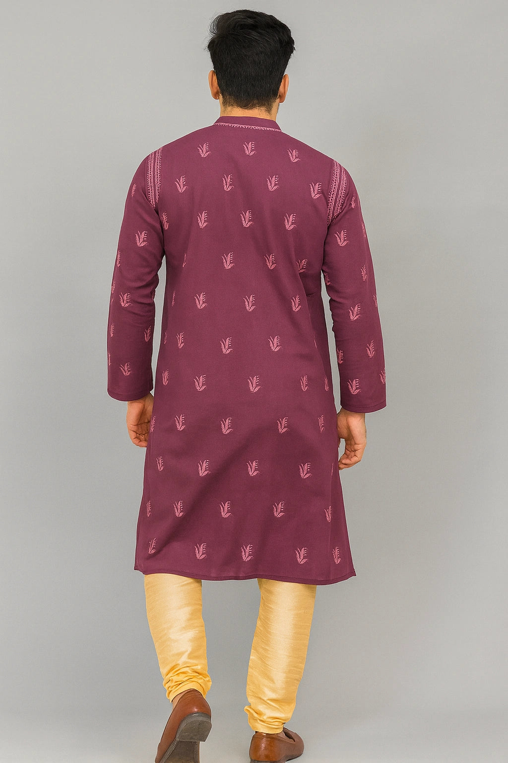 Man wearing a lucknowi chikankari mauve kurta with golden pants on a light gray background