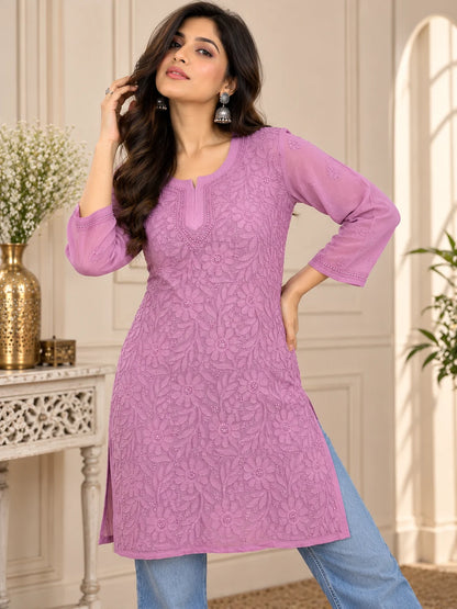 Woman wearing a lucknowi chikankari  mauve kurta with white floral patterns 