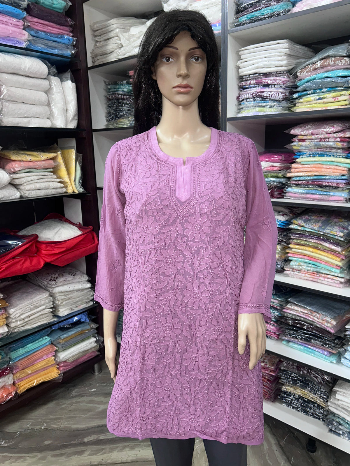 Woman wearing a lucknowi chikankari mauve-colored kurta with white patterns on a white background