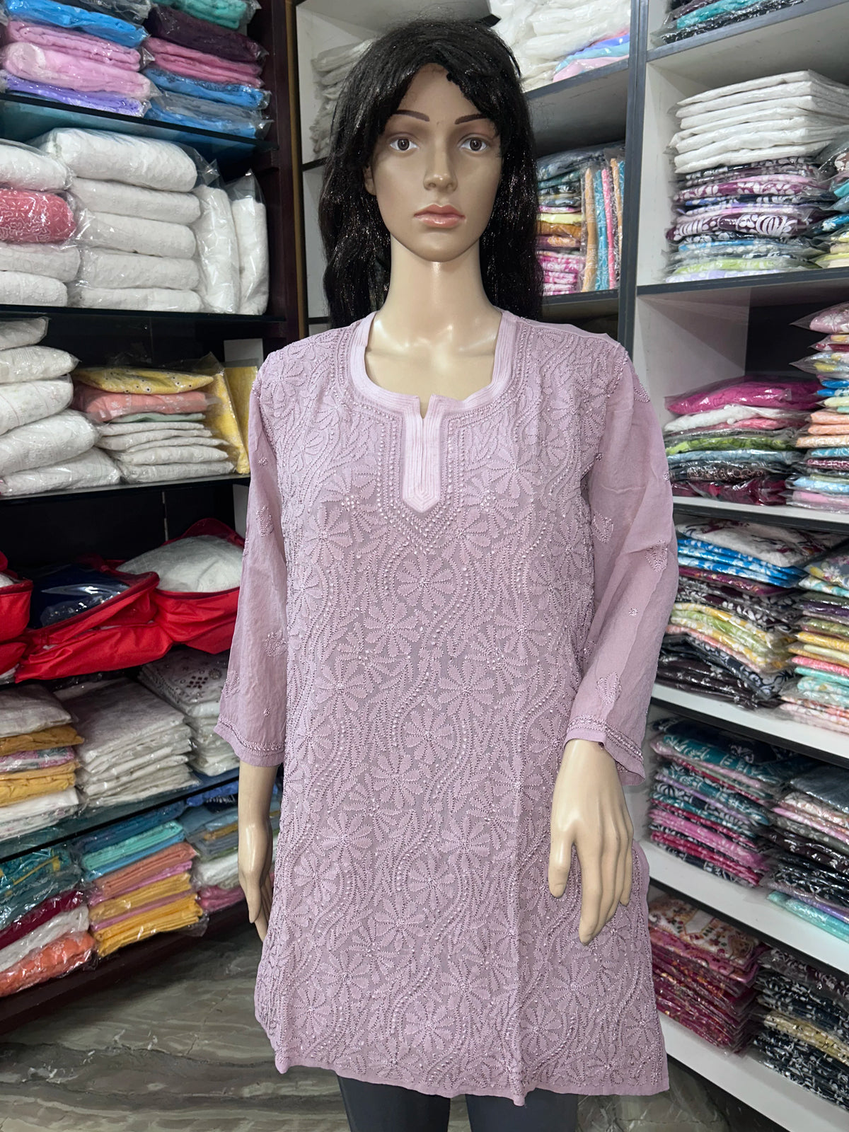Woman wearing a lucknowi chikankari mauve-colored kurta with white patterns on a white background