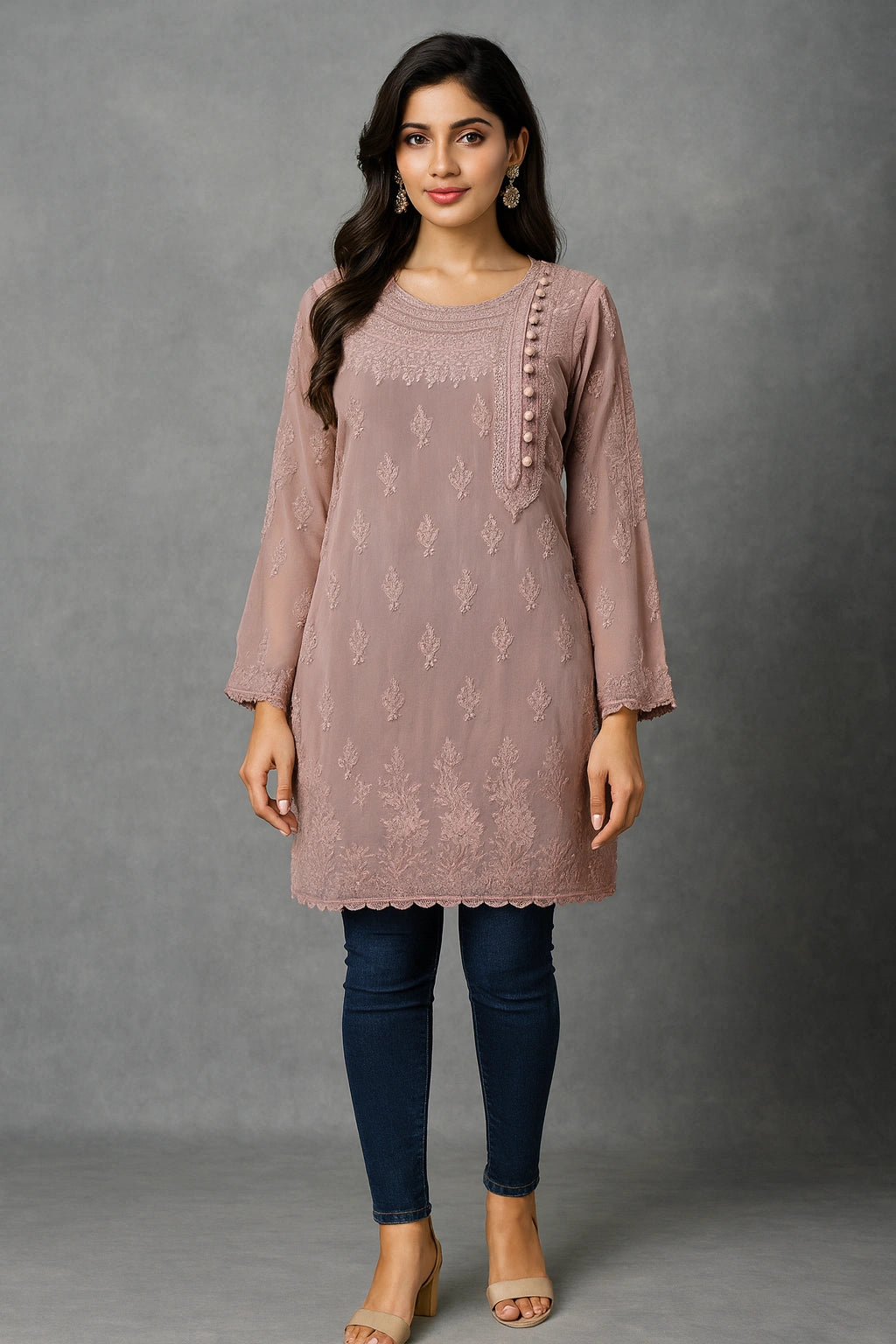 Woman wearing a mauve embroidered kurta with blue jeans against a gray background