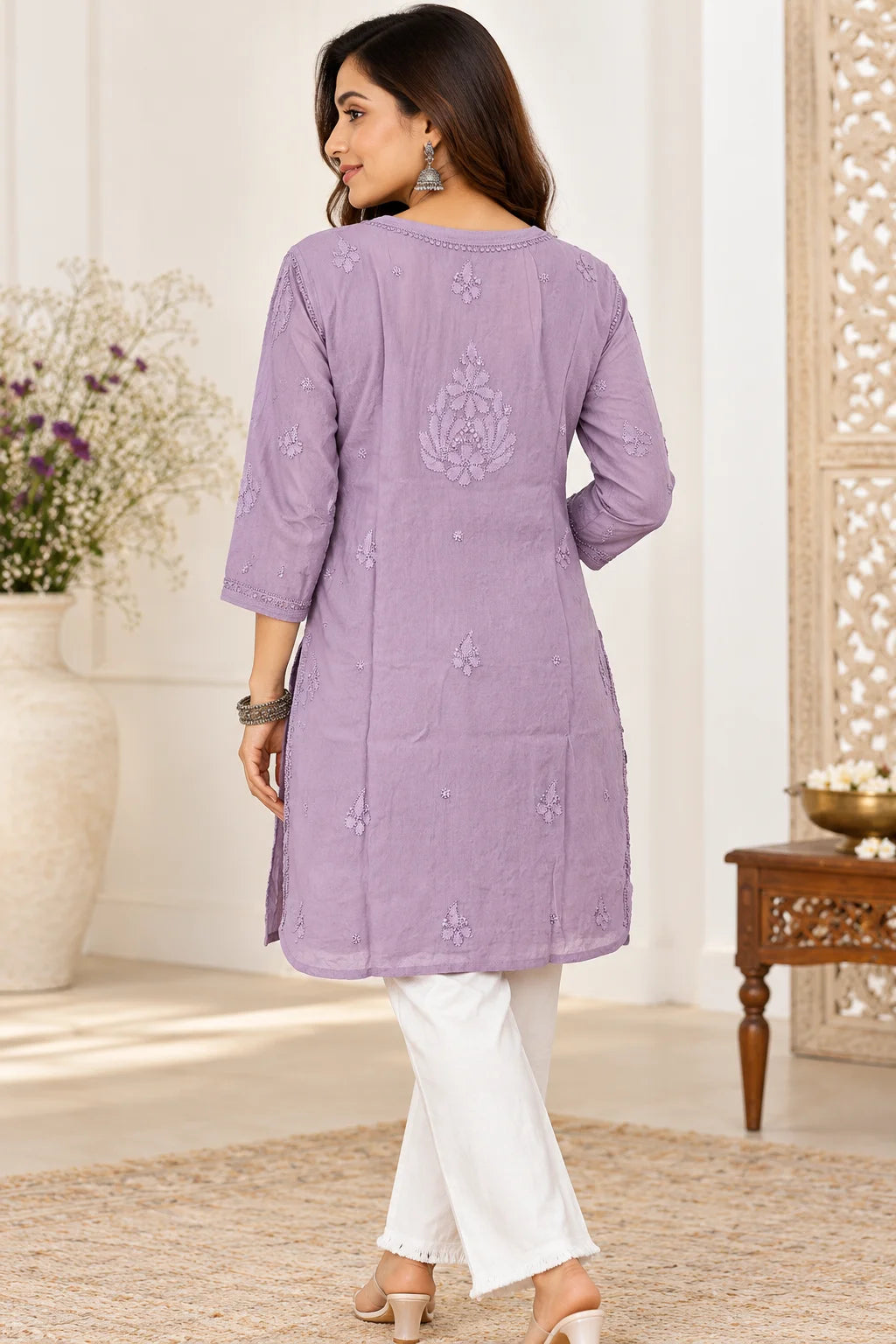 Woman wearing a lucknowi chikankari  mauve kurta with white floral patterns 
