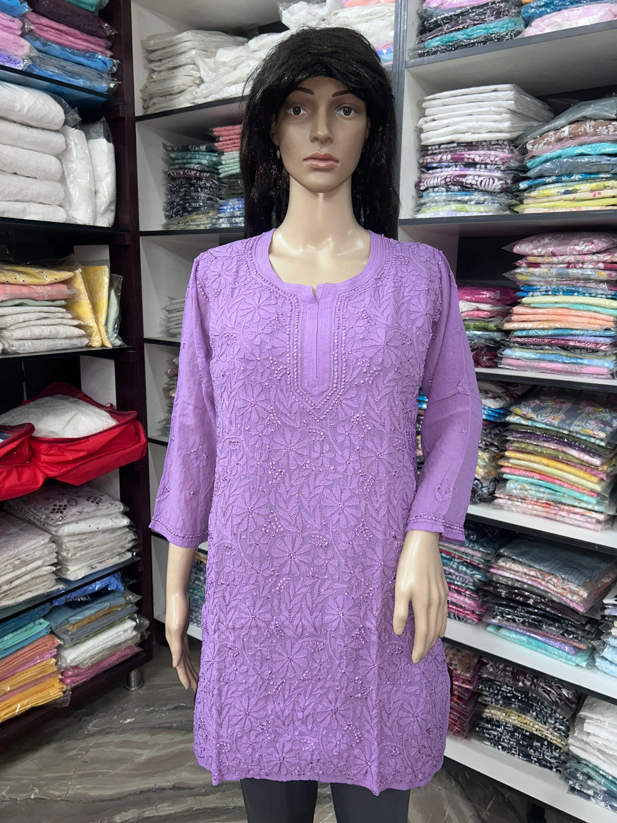 Woman wearing a lucknowi chikankari purple-colored kurta with white patterns on a white background