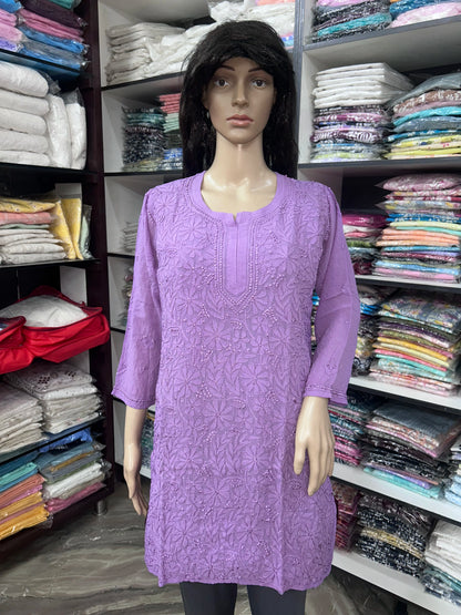 Woman wearing a lucknowi chikankari purple-colored kurta with white patterns on a white background