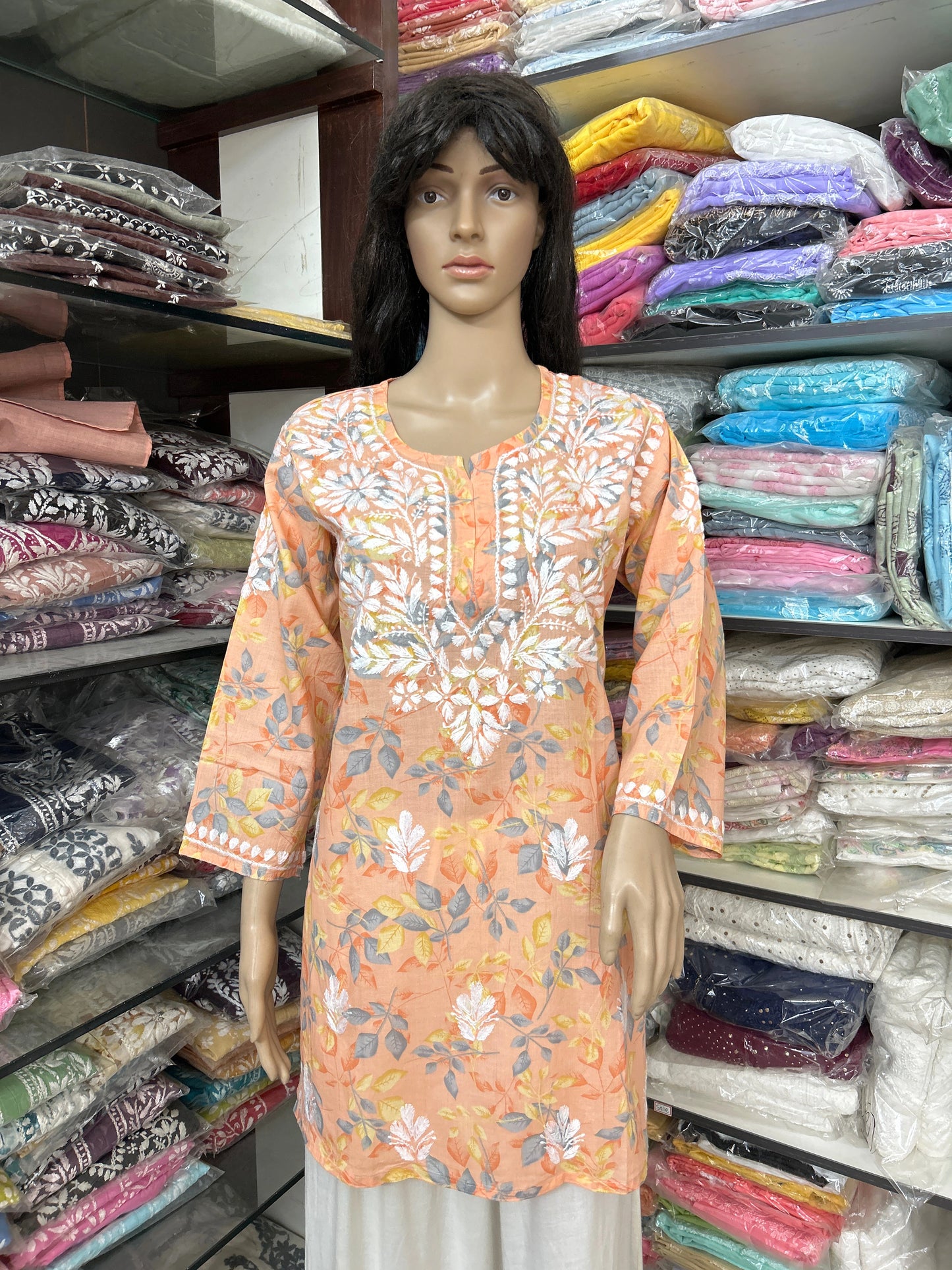 Mannequin wearing a floral embroidered top in a fabric store