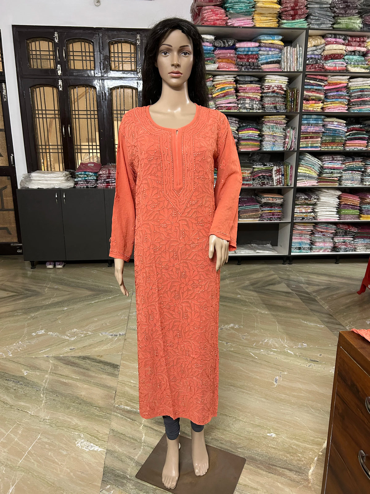 Mannequin wearing a lucknowi chikankari orange-colored kurta