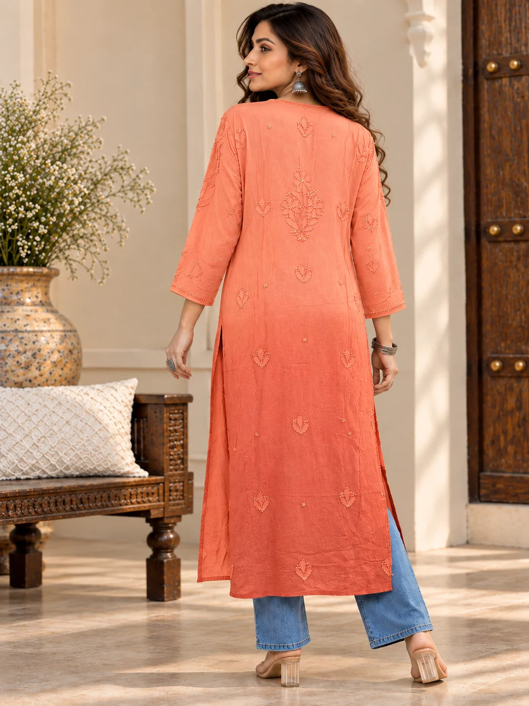Woman wearing a lucknowi chikankari orange-colored kurta