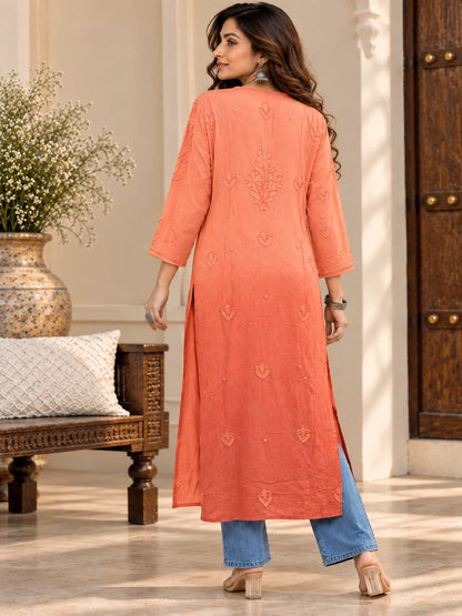 Woman wearing a lucknowi chikankari orange-colored kurta