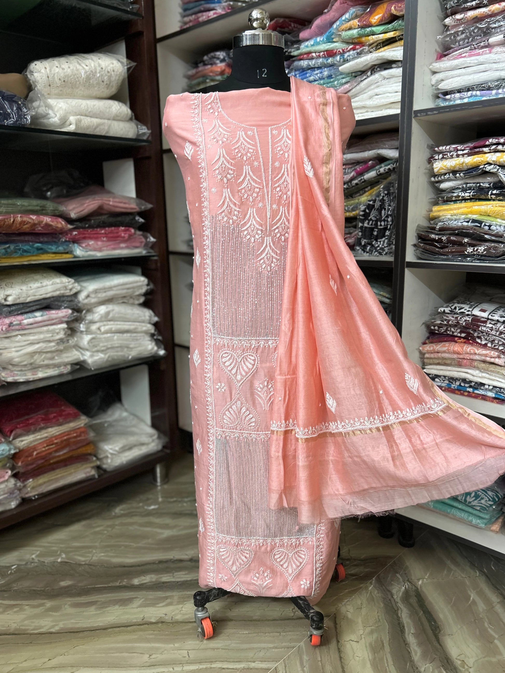 Pink embroidered dress on a mannequin in a fabric store