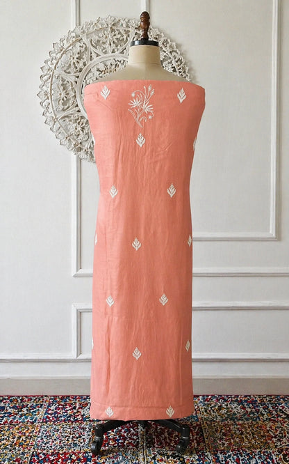 Lucknowi chikankari Peach-colored dress with white patterns on a mannequin against a decorative wall.