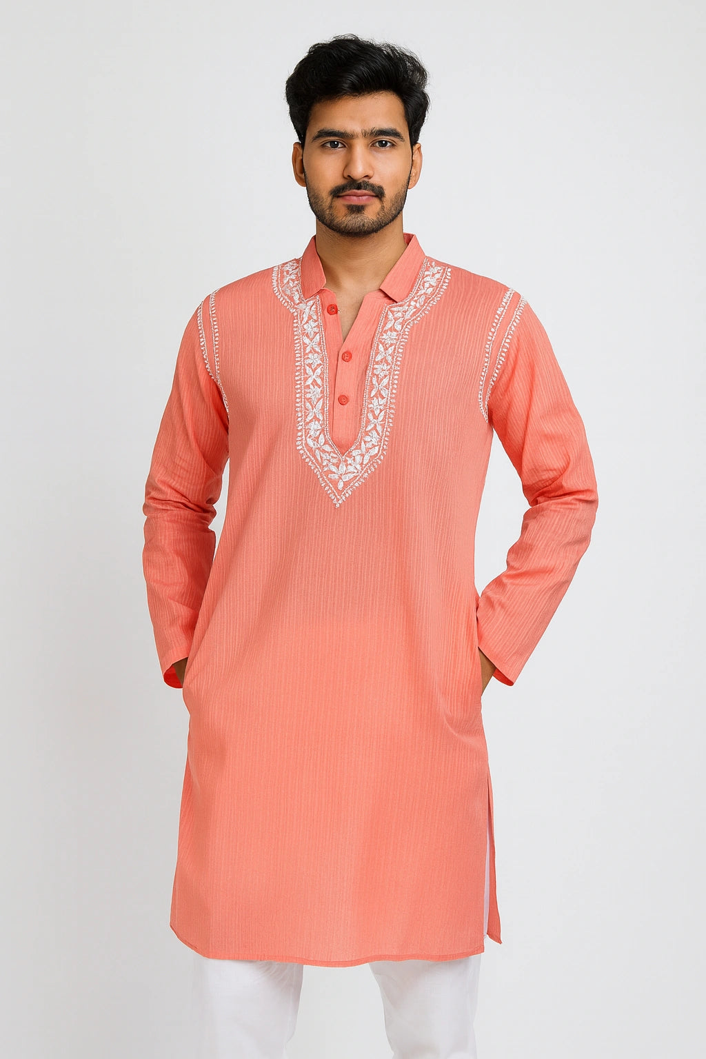 Man wearing a lucknowi chikankari peach kurta with white embroidery on a white background