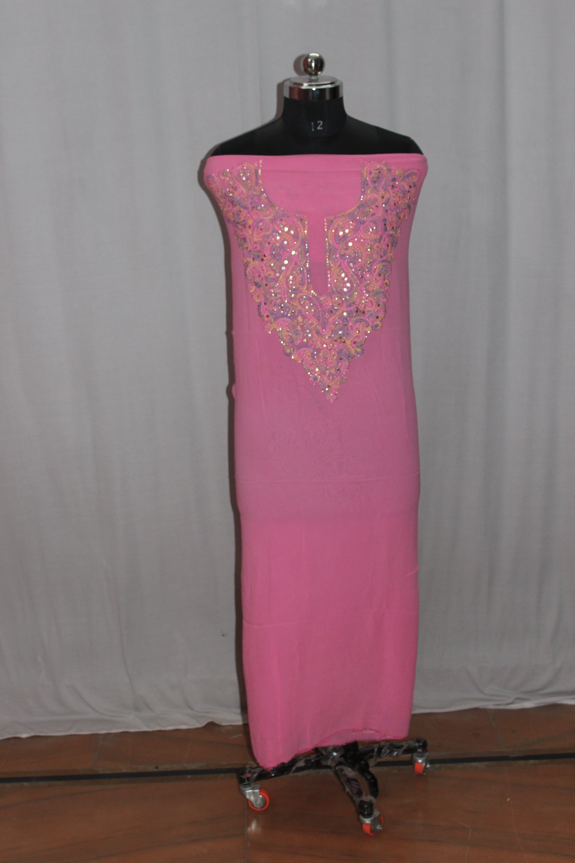lucknowi chikankari Pink dress with intricate beading on a mannequin against a plain background