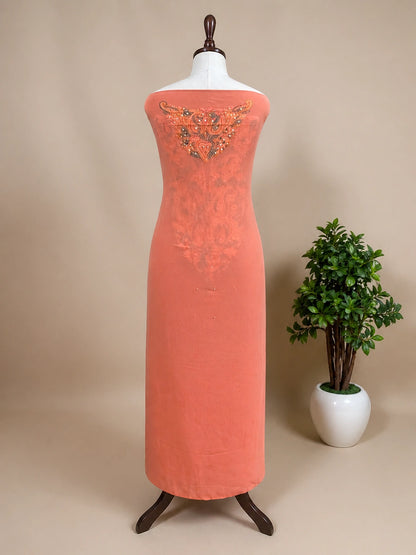 lucknowi chikankari peach dress with floral patterns on a mannequin against a gray wall with decorative panels.