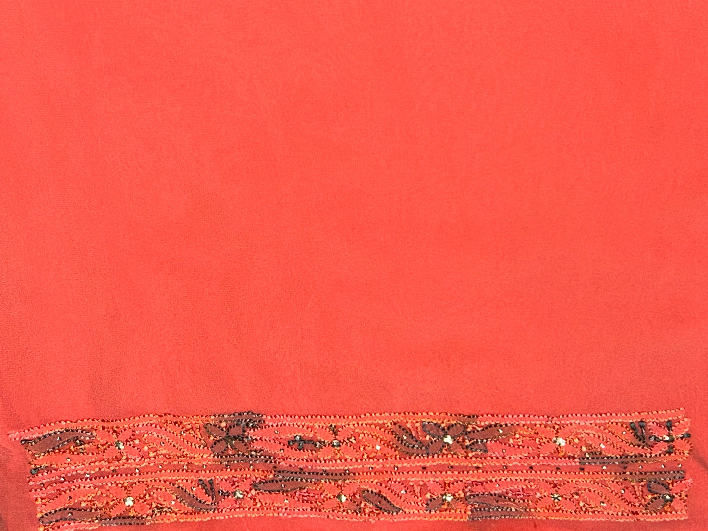 lucknowi chikankari Red fabric with decorative brown pattern on a red background