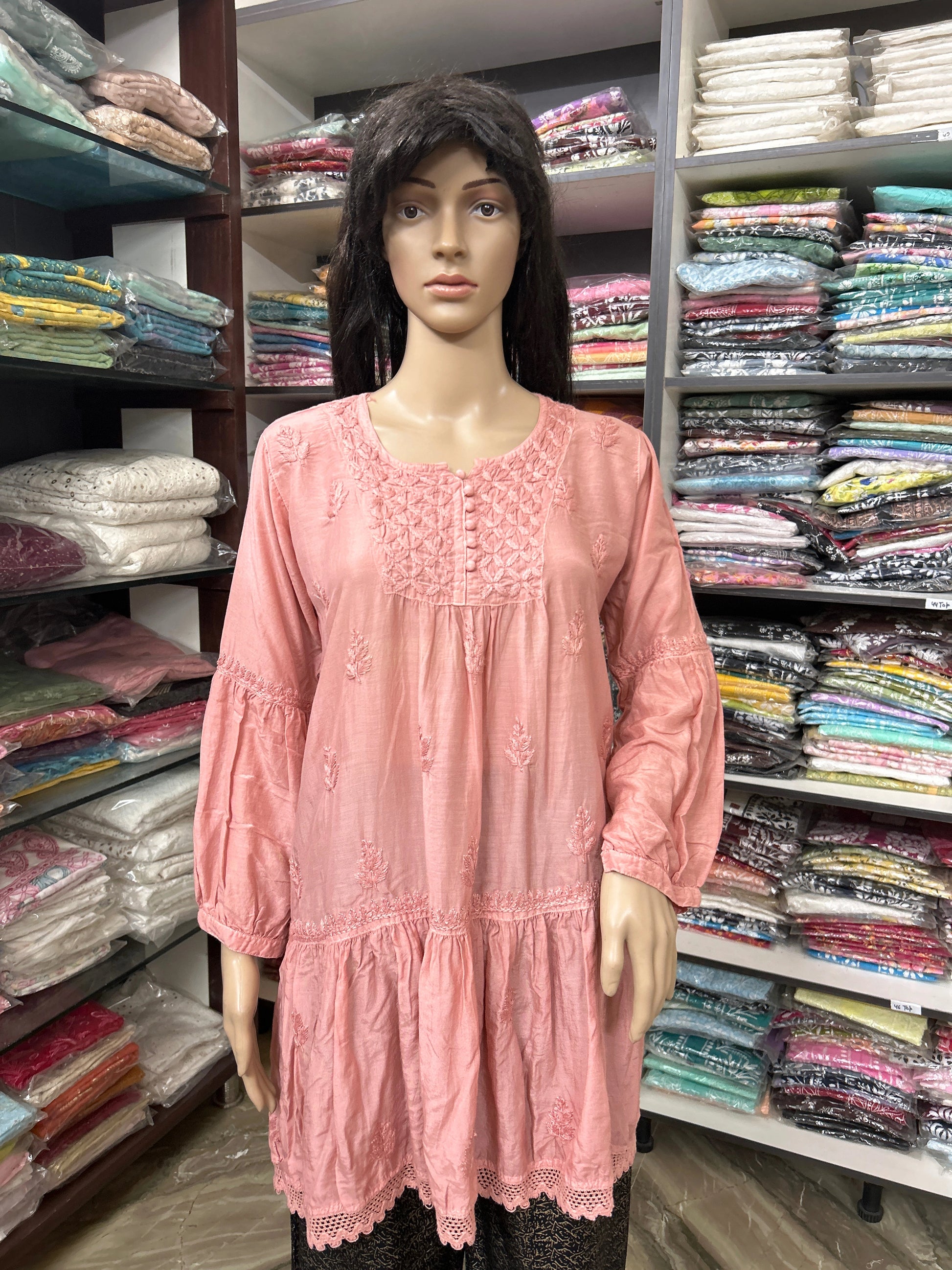 Mannequin wearing a lucknowi chikankari pink dress in a fabric store