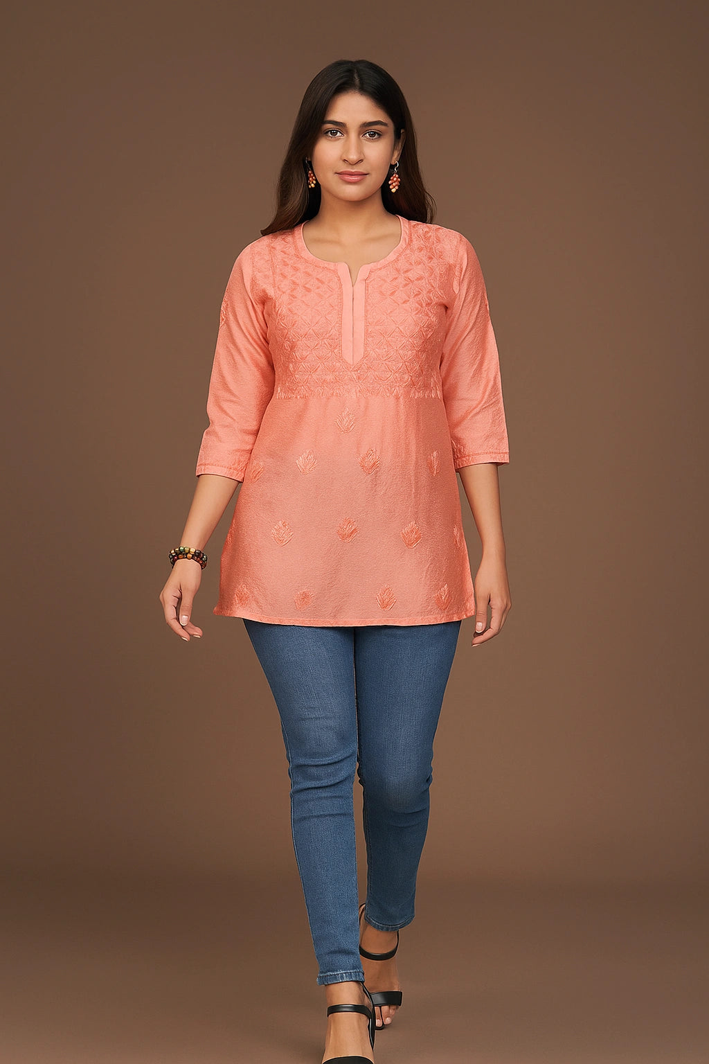 lucknowi chikankari Woman wearing a peach-colored kurta with blue jeans on a brown background