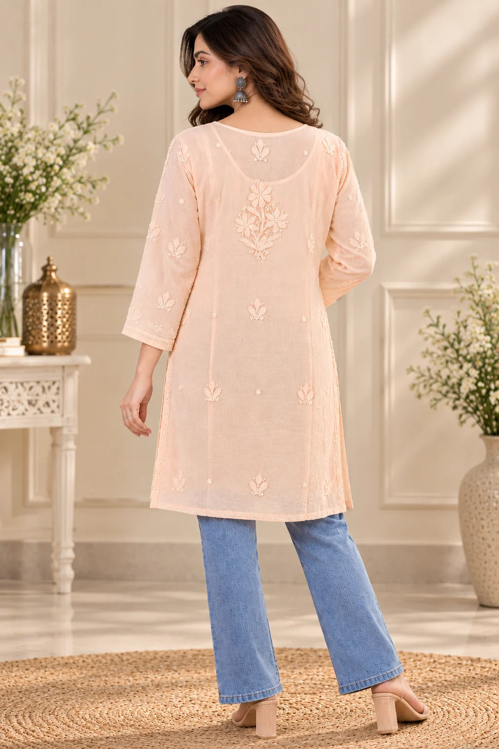 Woman wearing a lucknowi chikankari peach-colored kurta with white floral patterns