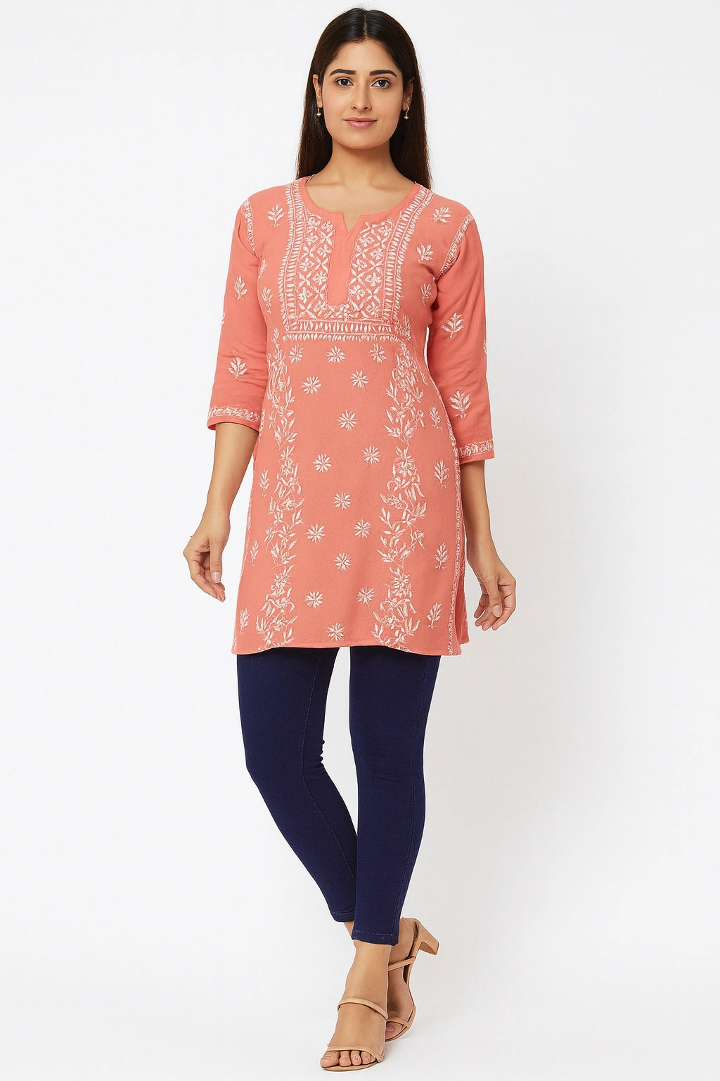 Woman wearing a lucknowi chikankari  coral pink kurta with white floral patterns on a white background