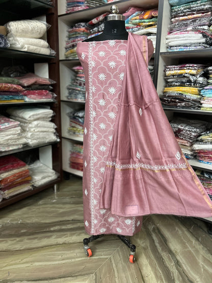 lucknowi chikankari Pink traditional outfit with white patterns on a mannequin in a fabric store.