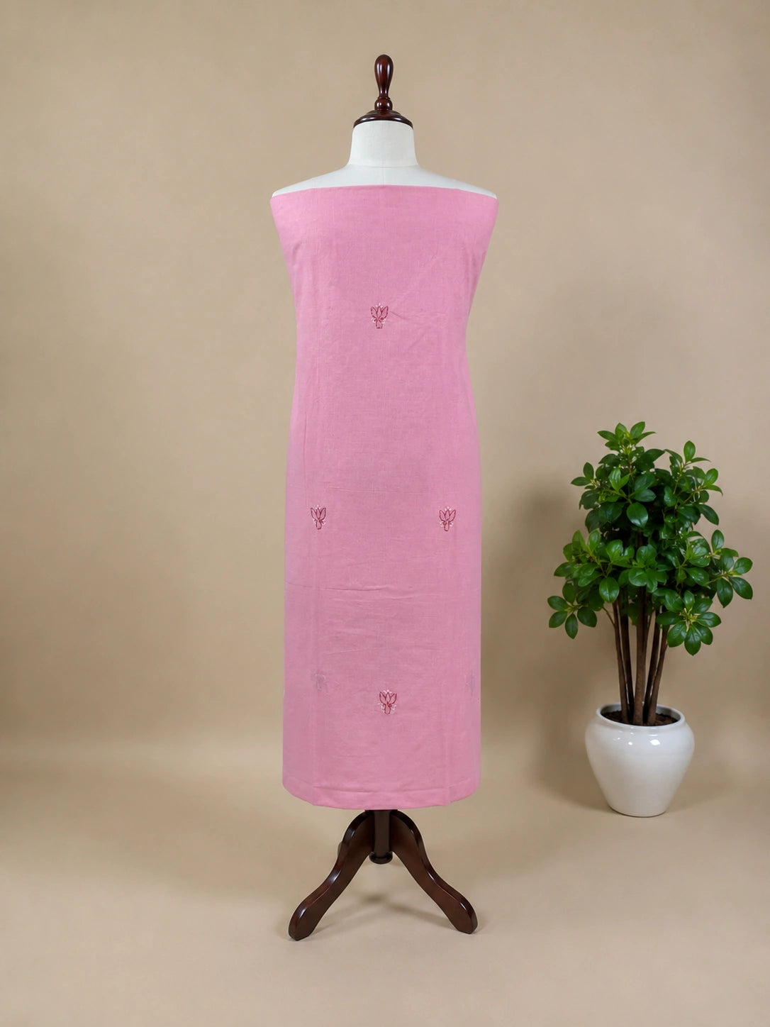 Lucknowi chikankari Mannequin wearing a pink towel with a plant on a beige background