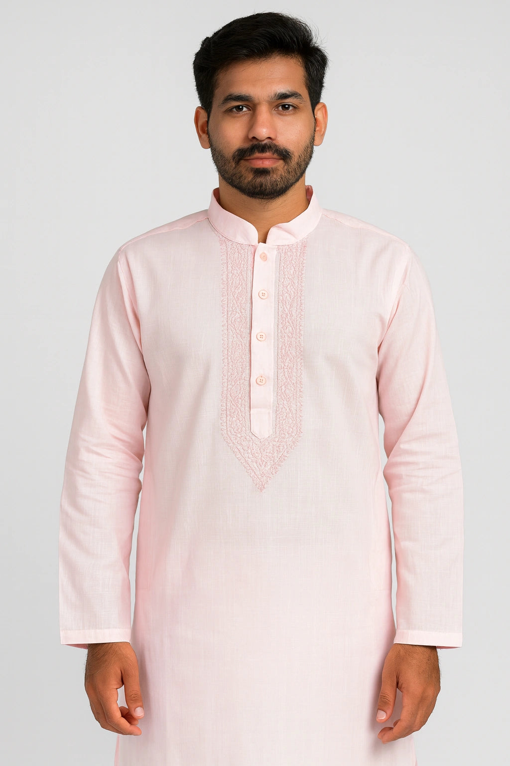 Man wearing a lucknowi chikankari light pink kurta with intricate detailing on a white background