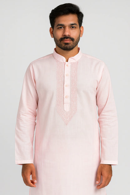 Man wearing a lucknowi chikankari light pink kurta with intricate detailing on a white background
